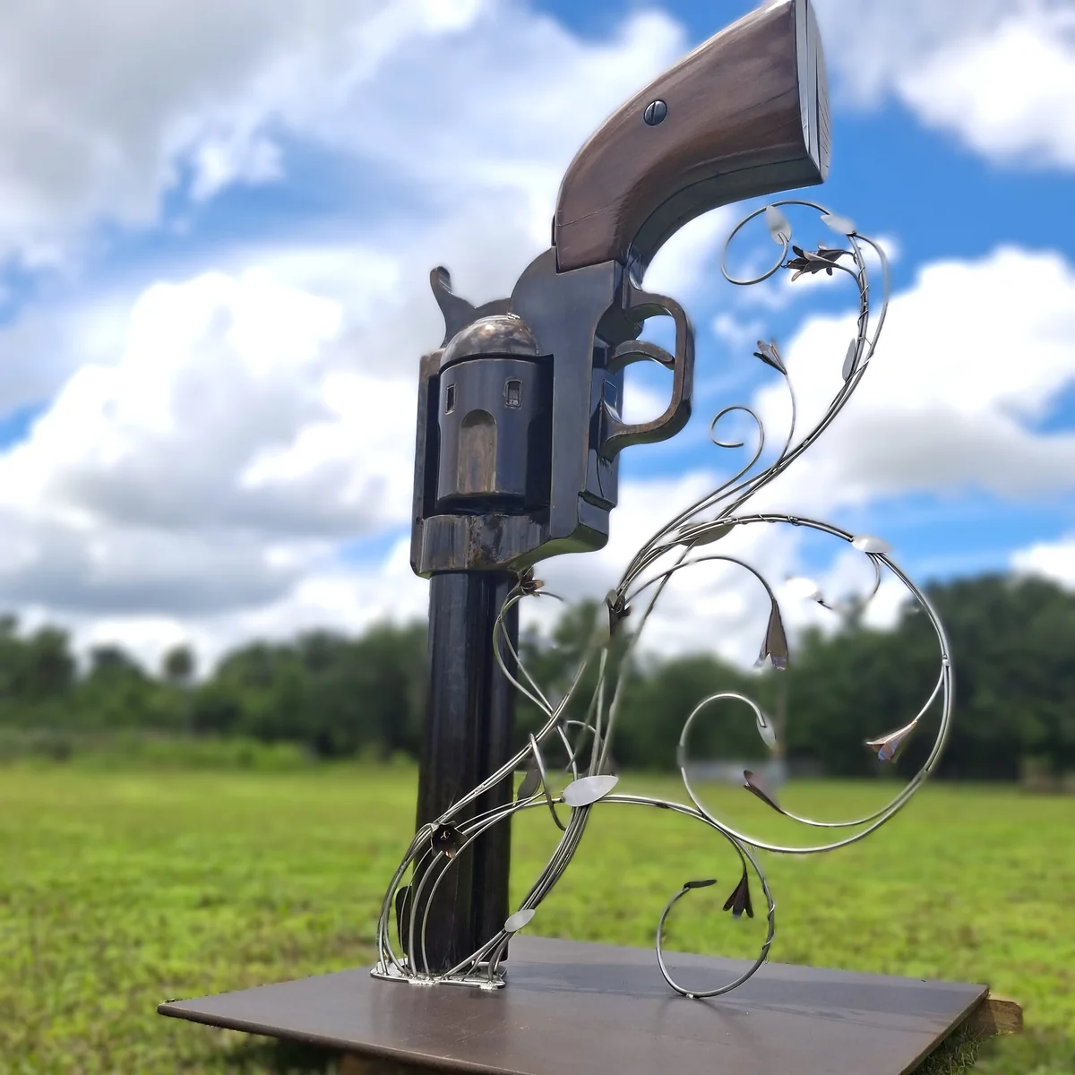 Low-angle view of the full big iron sculpture against the sky and open field.