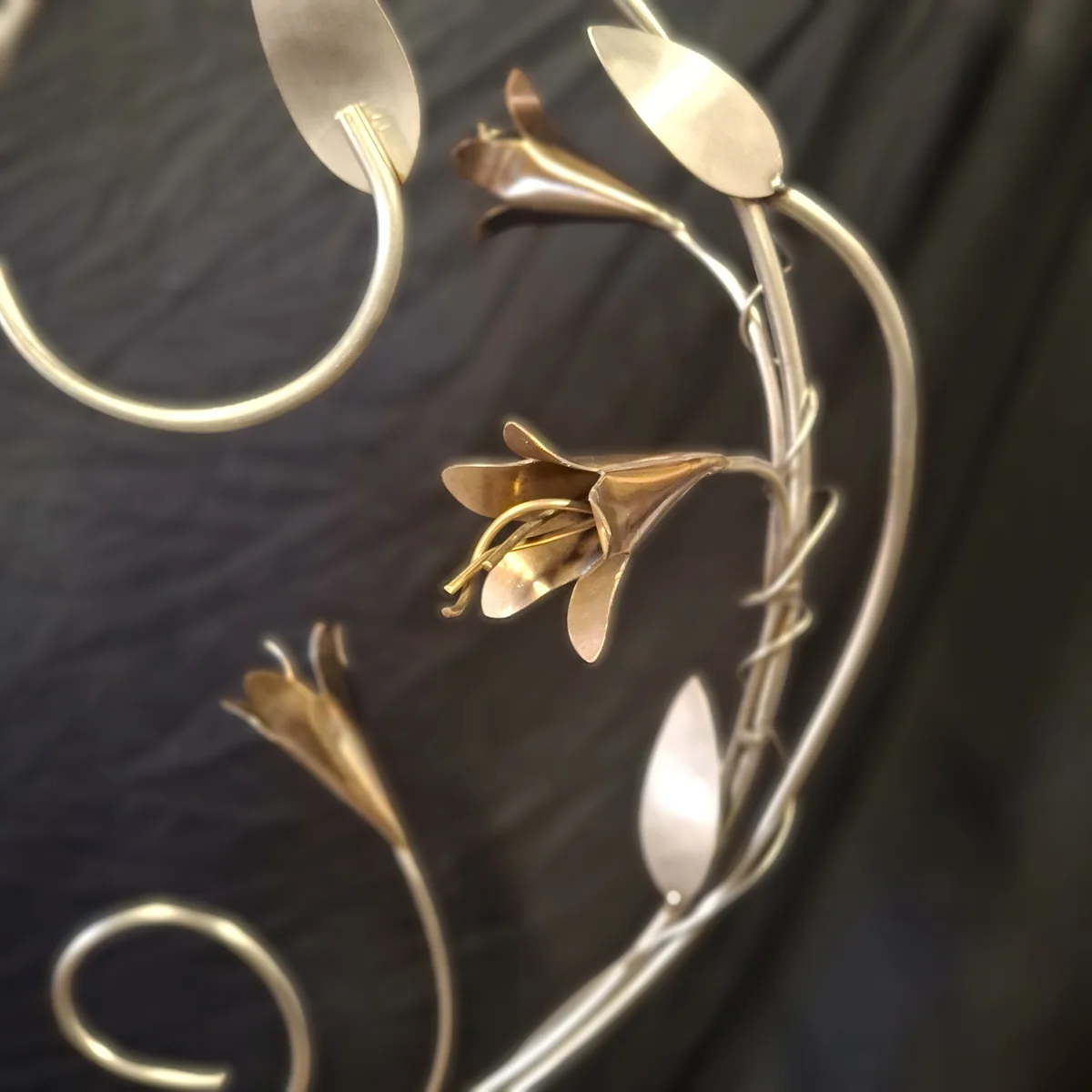 Soft-focus close view of metal flowers and curved stainless steel stems.