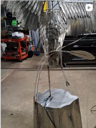 Feathered crane sculpture during fabrication, viewed from behind.