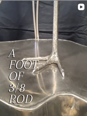 Close view of the crane sculpture's foot and lower legs resting on a metal surface.