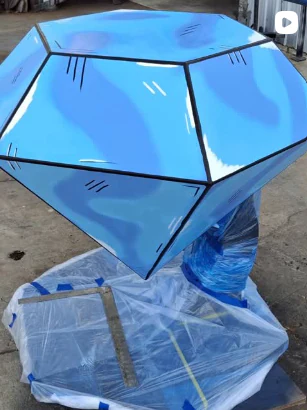 Blue diamond sculpture with graphic painted details.